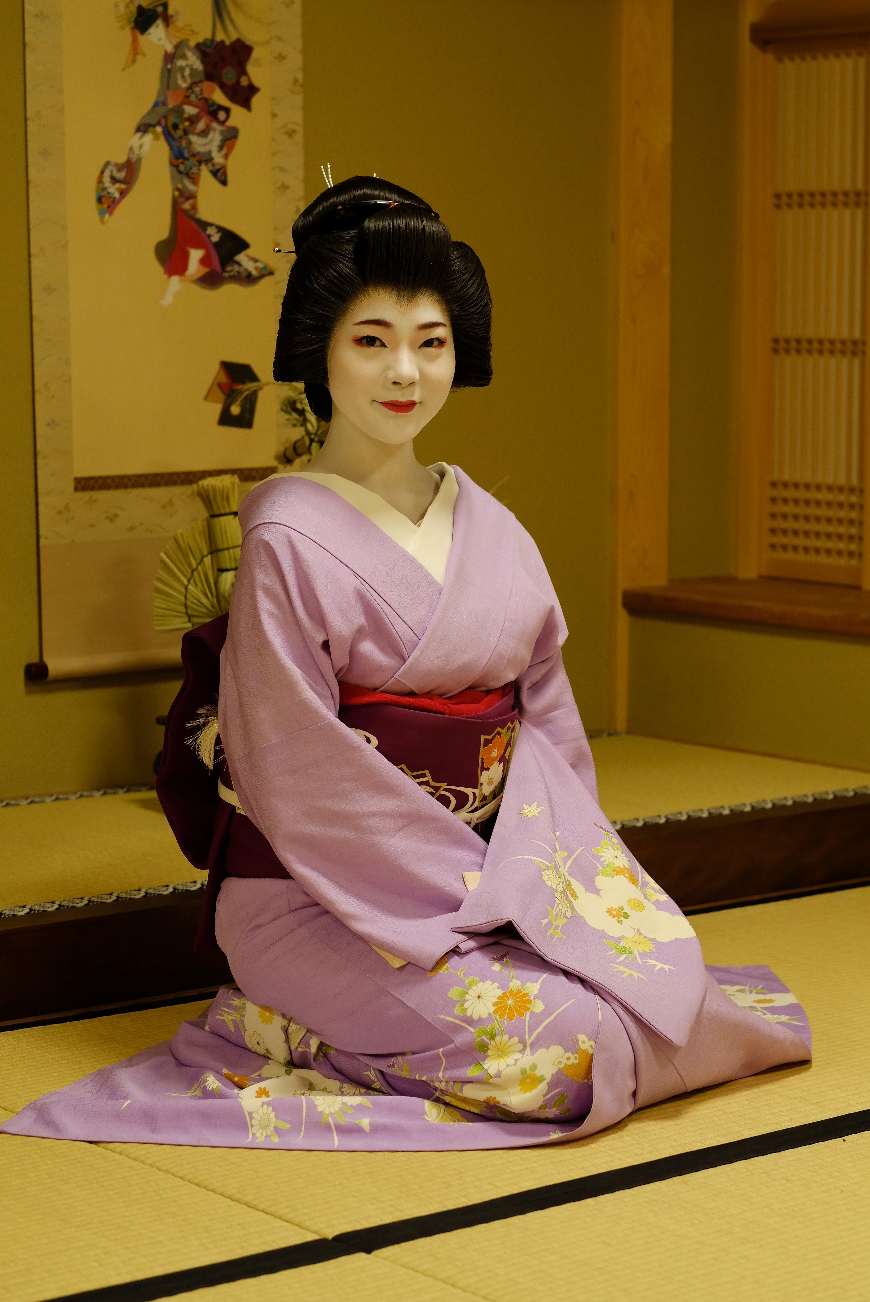 Eine Japanerin in traditioneller Kleidung sitzt im Seiza-Sitz auf dem Boden 